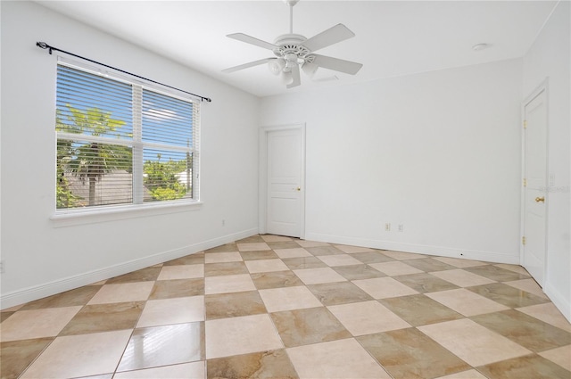 unfurnished room with ceiling fan and light tile flooring