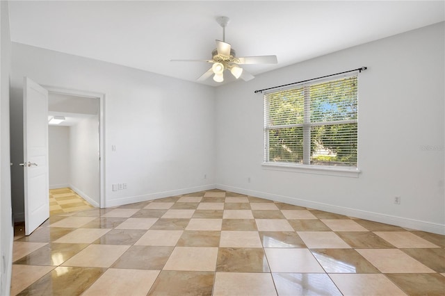 tiled spare room with ceiling fan