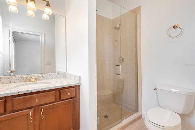 bathroom with a shower with door, vanity, tile floors, and toilet