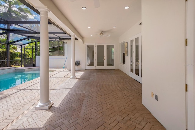 view of swimming pool featuring a patio area, ceiling fan, a lanai, and french doors