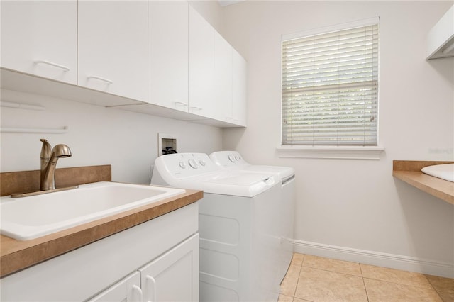 washroom with independent washer and dryer, hookup for a washing machine, light tile floors, sink, and cabinets