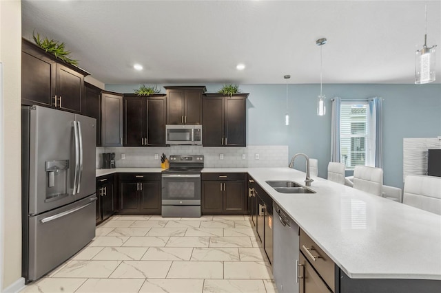 kitchen with sink, stainless steel appliances, hanging light fixtures, and kitchen peninsula