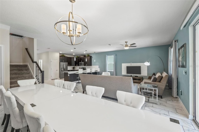 dining room featuring ceiling fan with notable chandelier