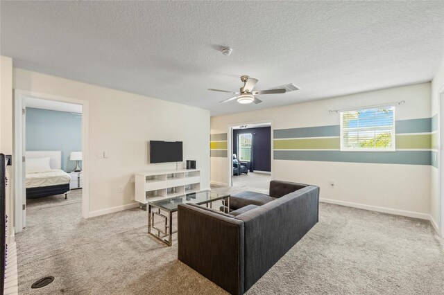 carpeted living room featuring a textured ceiling and ceiling fan