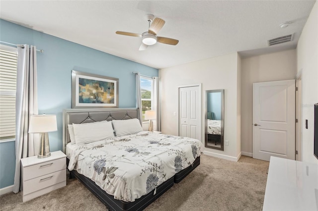 carpeted bedroom with ceiling fan and a closet