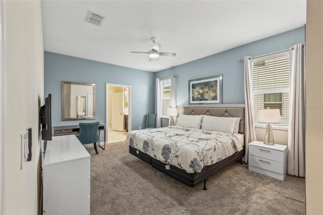 carpeted bedroom with ceiling fan and connected bathroom