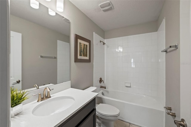 full bathroom featuring tiled shower / bath combo, vanity, a textured ceiling, and toilet