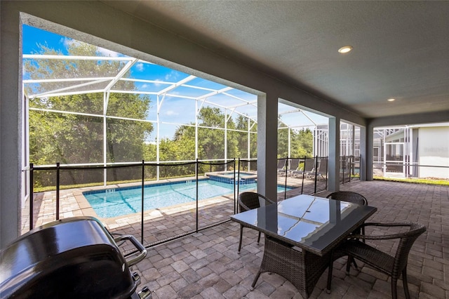 view of swimming pool with an in ground hot tub, a patio area, and glass enclosure