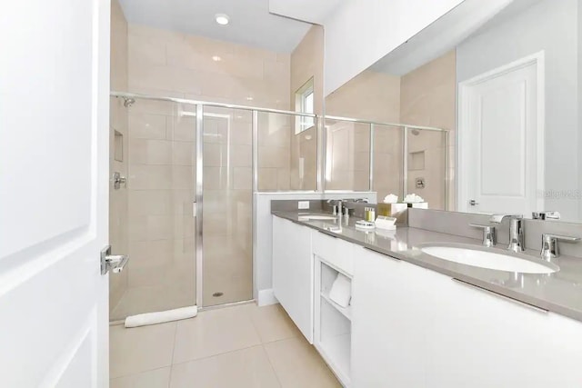 bathroom featuring walk in shower, double sink, tile floors, and large vanity