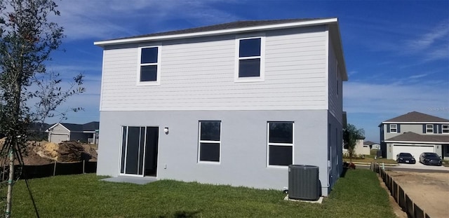 rear view of house with a yard and cooling unit