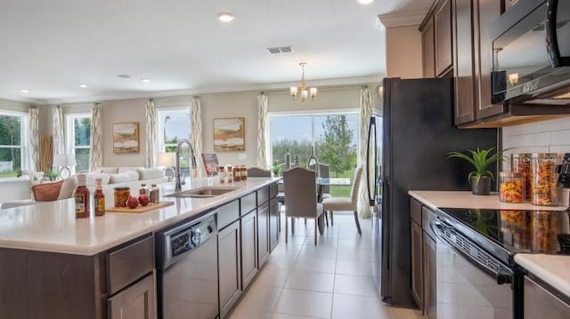 kitchen with dark brown cabinets, sink, a wealth of natural light, and black appliances