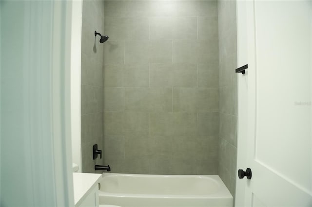 bathroom with tiled shower / bath combo and vanity