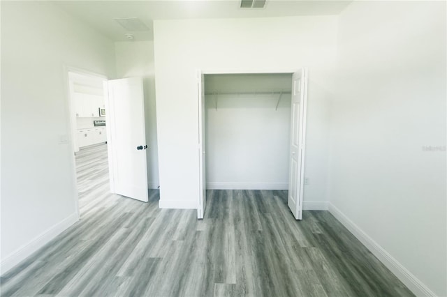 unfurnished bedroom with hardwood / wood-style flooring and a closet