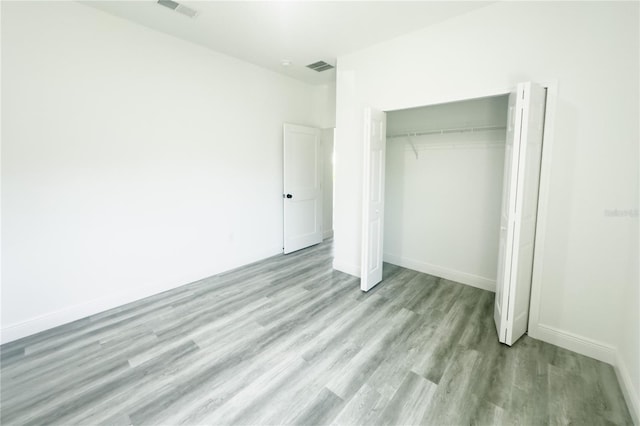 unfurnished bedroom with a closet and light wood-type flooring