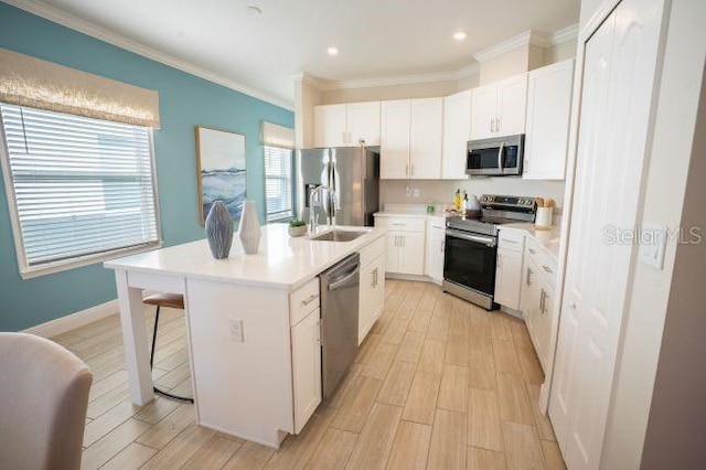 kitchen with white cabinetry, stainless steel appliances, an island with sink, and a breakfast bar area