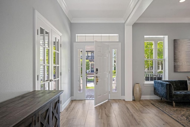 foyer with ornamental molding and light hardwood / wood-style flooring