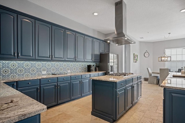 kitchen with blue cabinets, appliances with stainless steel finishes, light tile floors, a kitchen island, and island exhaust hood