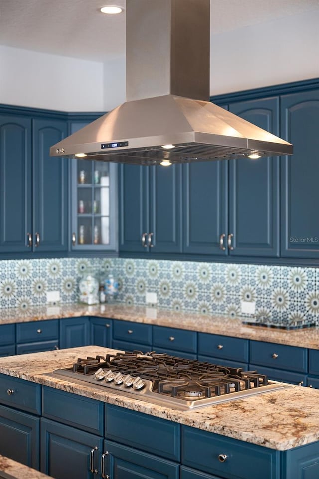 kitchen featuring blue cabinets, island exhaust hood, and tasteful backsplash