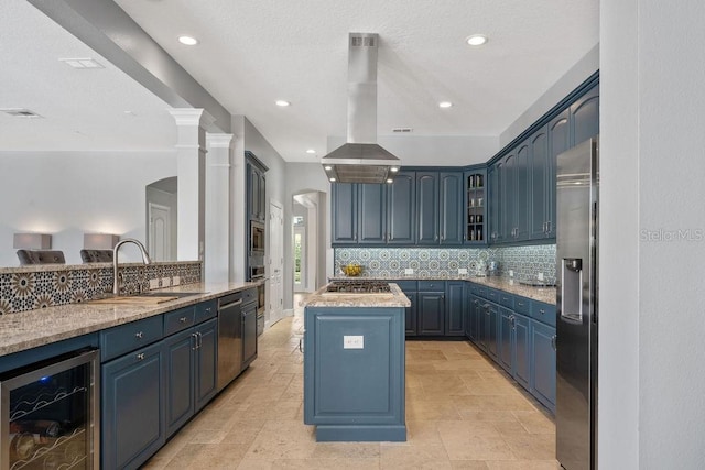 kitchen with beverage cooler, island range hood, stainless steel appliances, blue cabinetry, and a kitchen island