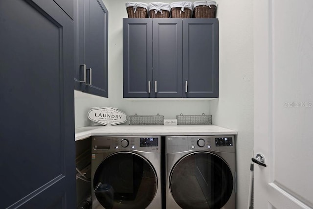 laundry area with washer and dryer and cabinets