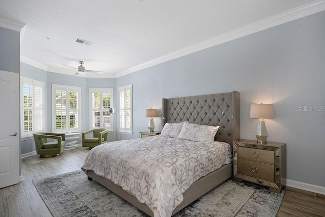 bedroom featuring crown molding, light hardwood / wood-style flooring, and ceiling fan