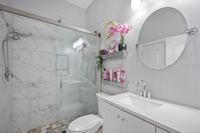 bathroom featuring vanity, a shower with shower door, and toilet