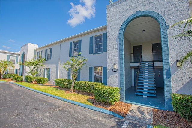 1048 Plantation Dr Unit E-9, Kissimmee, FL 34741 - view of front facade with stairway and stucco siding