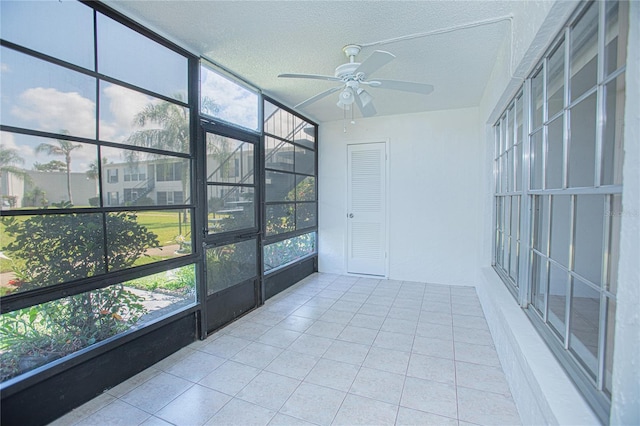 unfurnished sunroom with ceiling fan and plenty of natural light