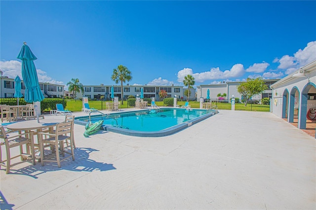 view of swimming pool with a patio area and a yard