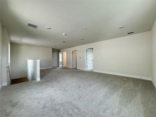 spare room featuring baseboards, visible vents, and carpet flooring