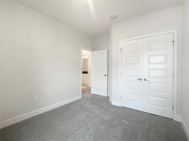 unfurnished bedroom featuring baseboards, a closet, visible vents, and carpet flooring