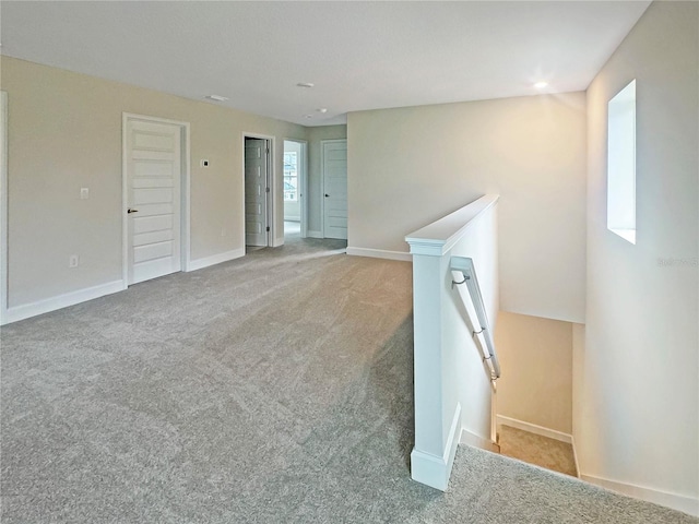 spare room with baseboards and carpet flooring