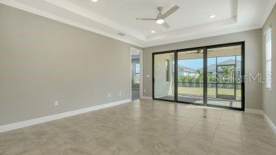 unfurnished room featuring a raised ceiling, ceiling fan, and crown molding