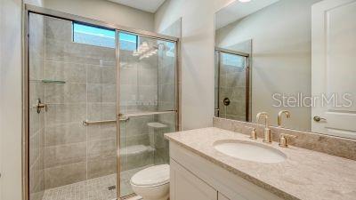 bathroom with vanity, an enclosed shower, and toilet