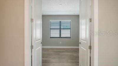 hallway with wood-type flooring and a textured ceiling