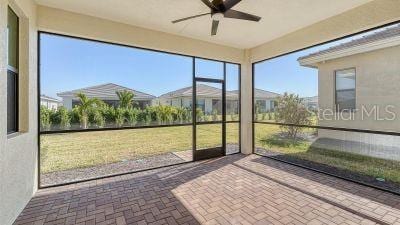 unfurnished sunroom with ceiling fan