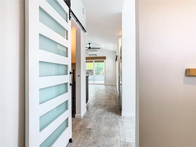 hallway with a barn door, lofted ceiling, built in features, and an AC wall unit