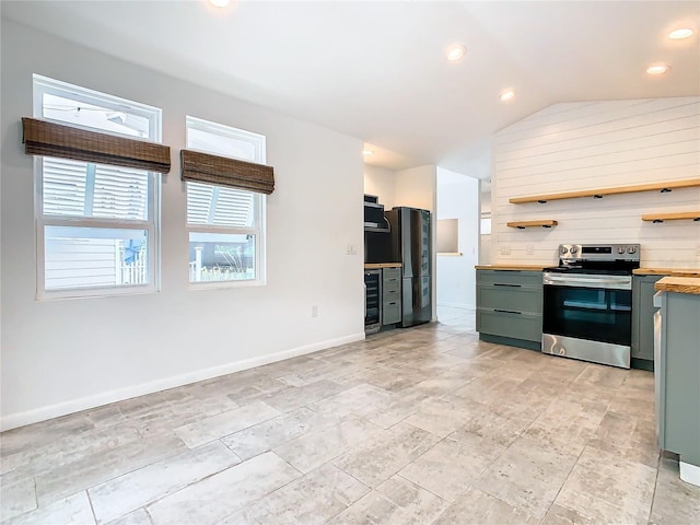 kitchen with black fridge, wine cooler, light tile flooring, stainless steel electric range, and vaulted ceiling