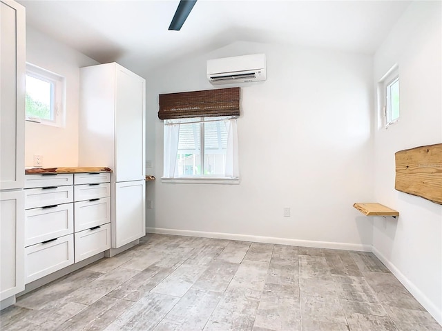 interior space featuring vanity, vaulted ceiling, and a wall mounted air conditioner