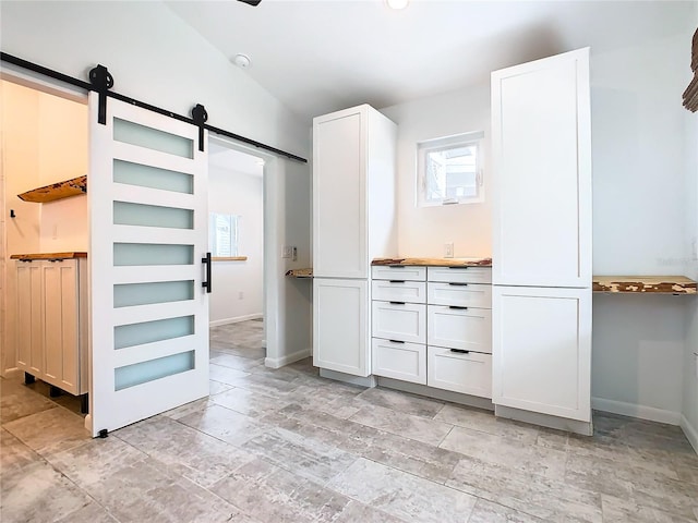 interior space with a barn door and light tile floors