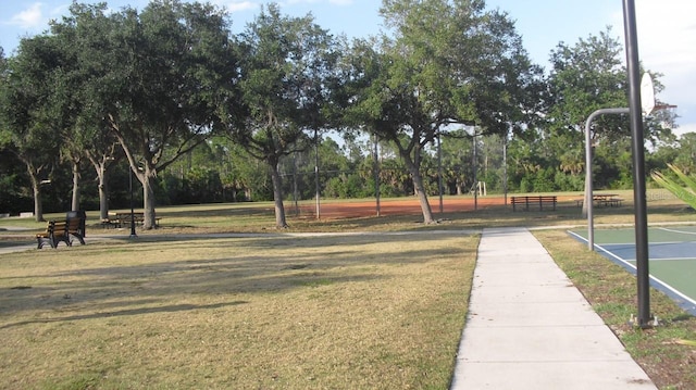 surrounding community featuring a yard and basketball hoop