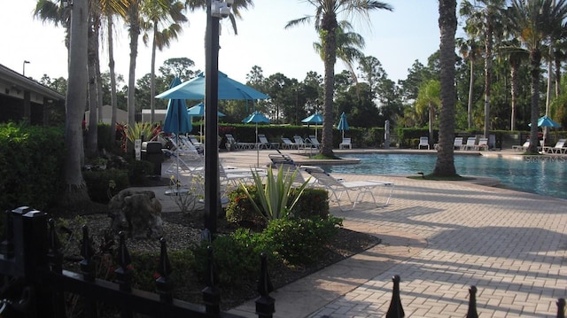 community pool with fence and a patio area