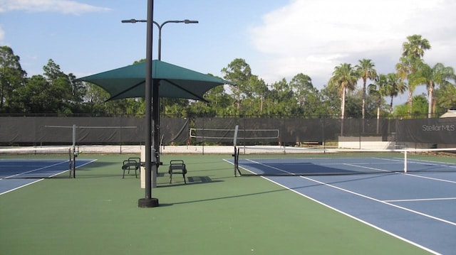 view of tennis court featuring fence