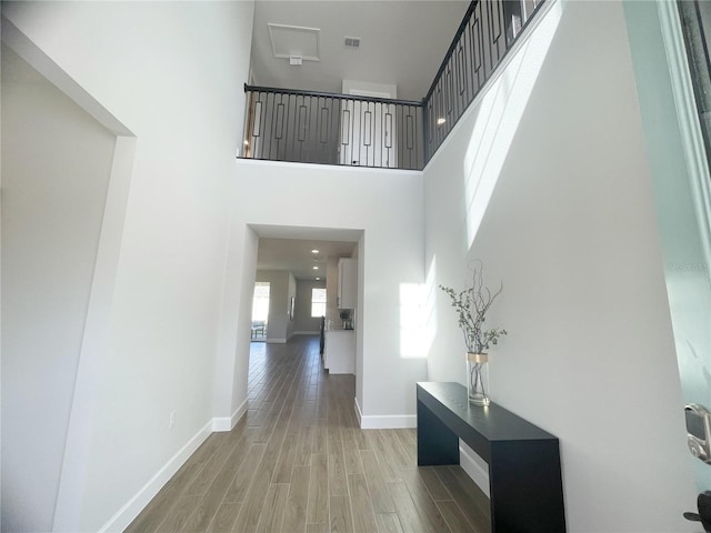 hallway featuring hardwood / wood-style floors and a high ceiling