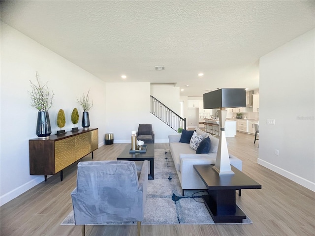 living room with light wood-type flooring and a textured ceiling