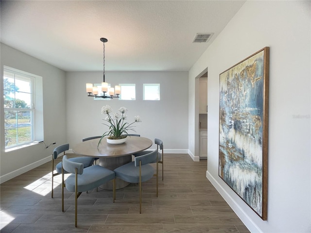 dining area featuring dark wood-type flooring and a chandelier