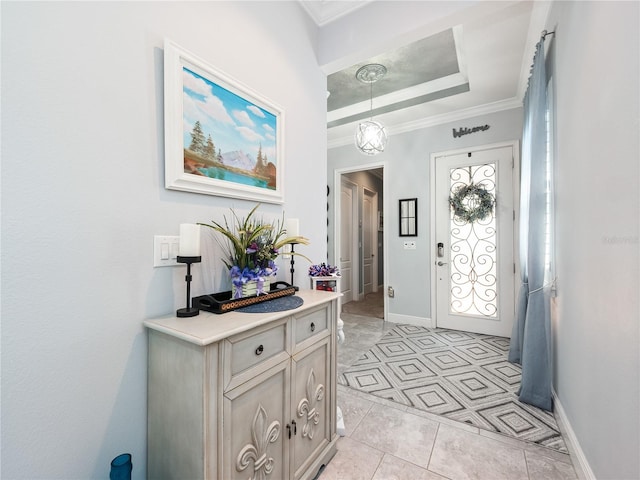 foyer entrance featuring light tile floors, ornamental molding, and a raised ceiling