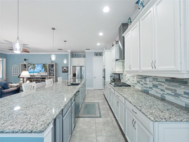 kitchen featuring crown molding, stainless steel appliances, a large island, sink, and ceiling fan