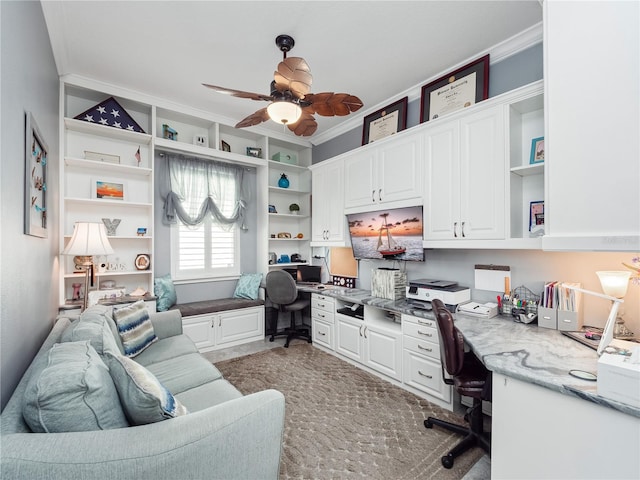 office area with built in features, ceiling fan, built in desk, and crown molding