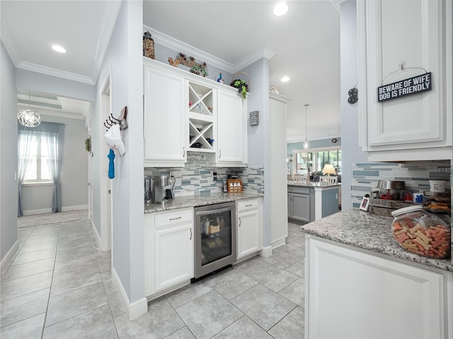 kitchen with wine cooler, light stone counters, plenty of natural light, and tasteful backsplash